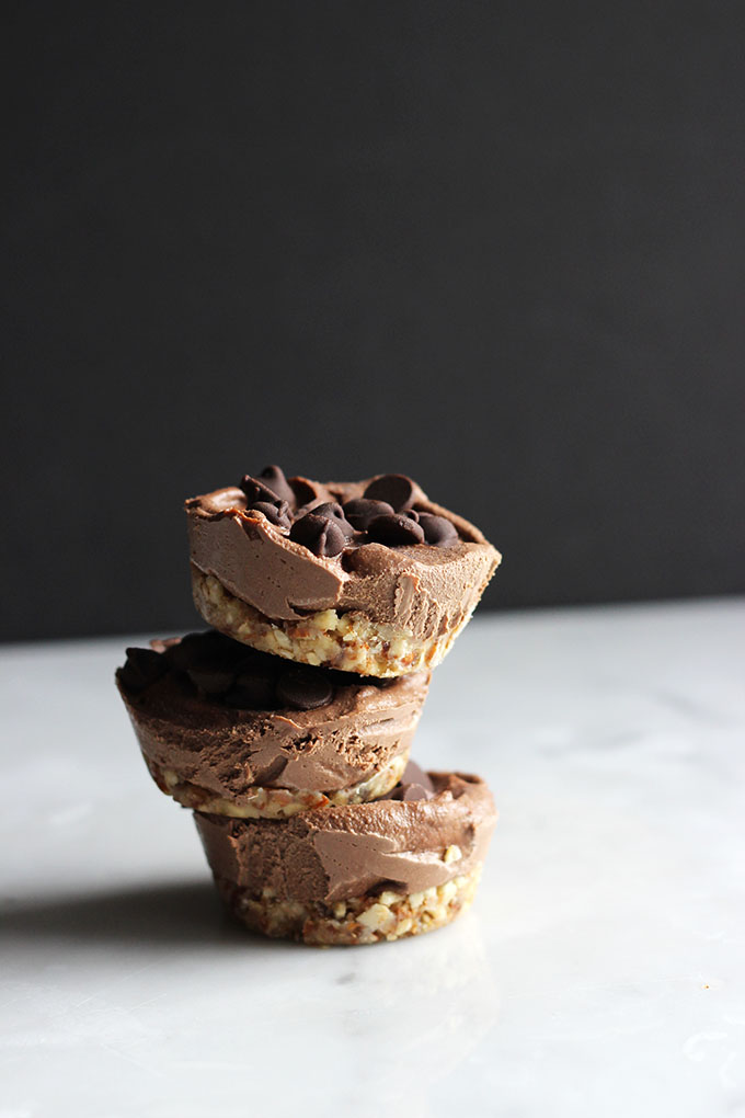 3 mini Vegan Mocha Cheesecakes stacked on a white table. 