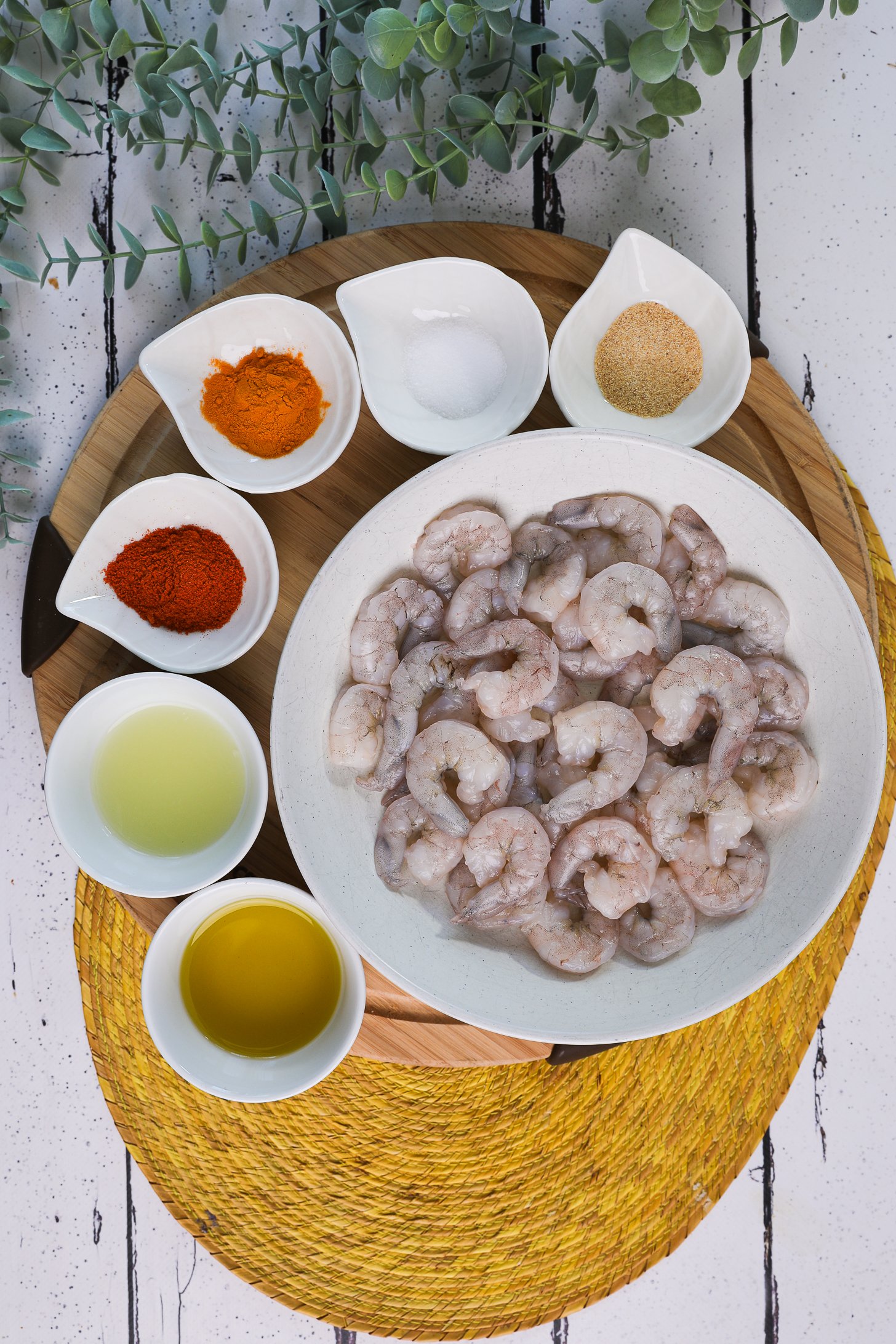 A selection of food ingredients including raw shrimp and powdered spices.