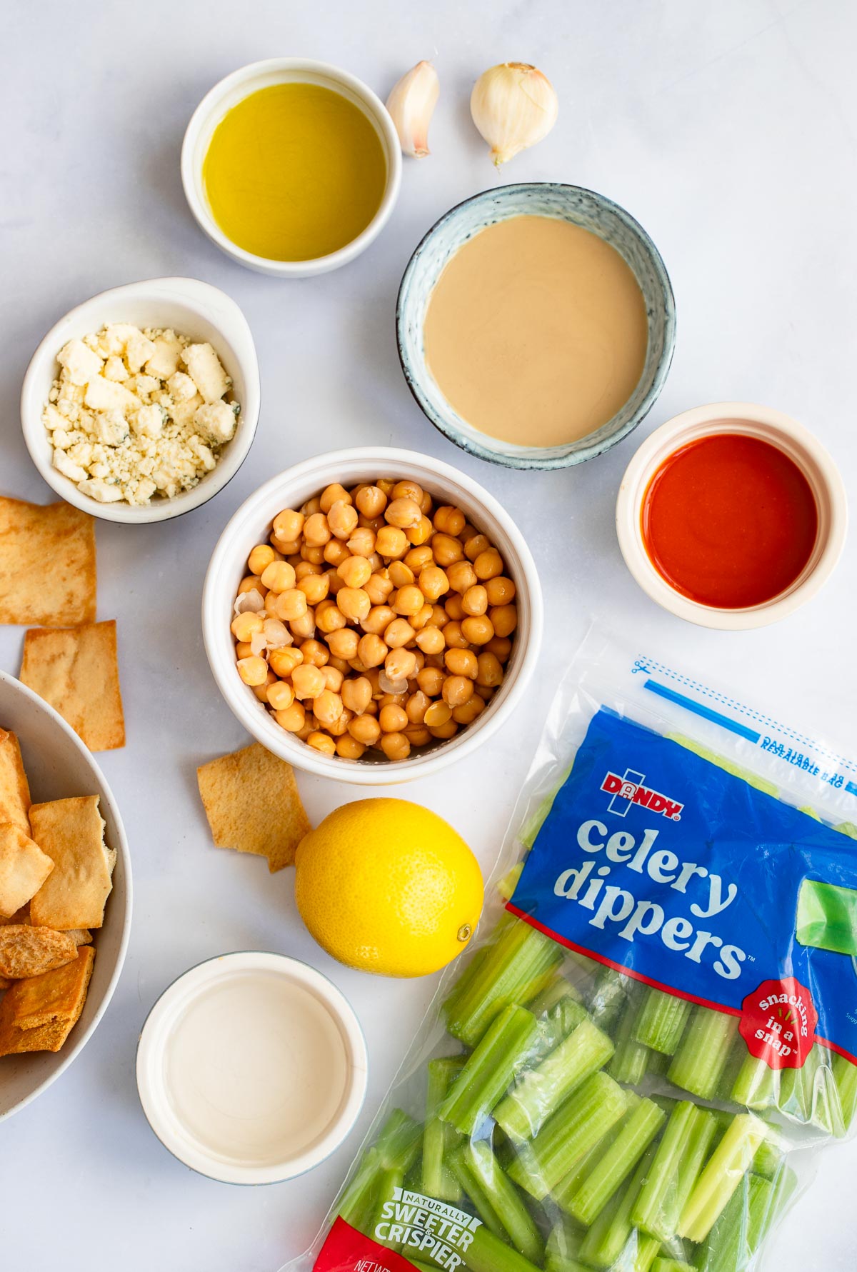 buffalo hummus ingredients in small dishes on a white background. 