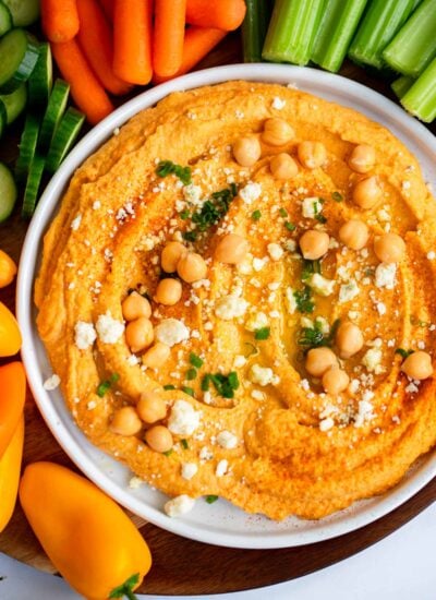 buffalo hummus on a plate garnished with blue cheese and chives. 