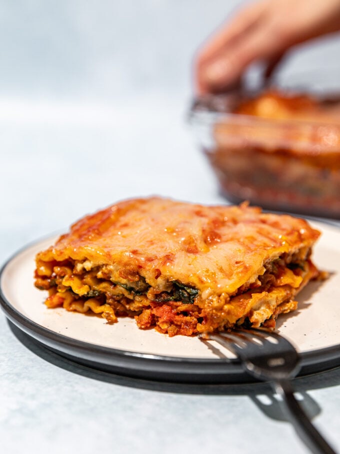 vegan lasagna on white plate with fork